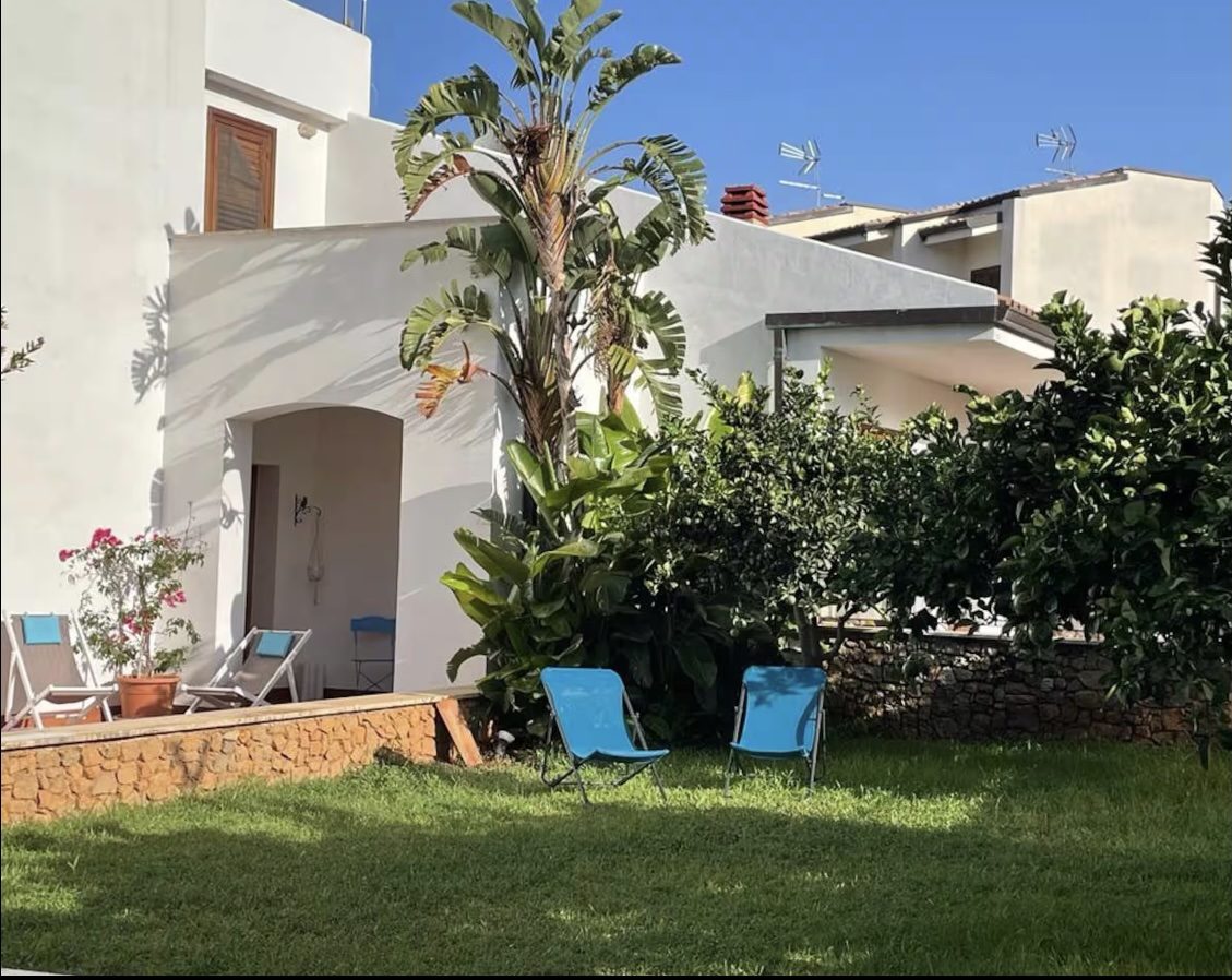 Garden of Villa Lisa with palm tree and blue chairs